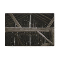 Rustic barn interior framed canvas print — moody looking-up view of weathered wooden beams and rafters with pinpoints of light, farmhouse photography wall art