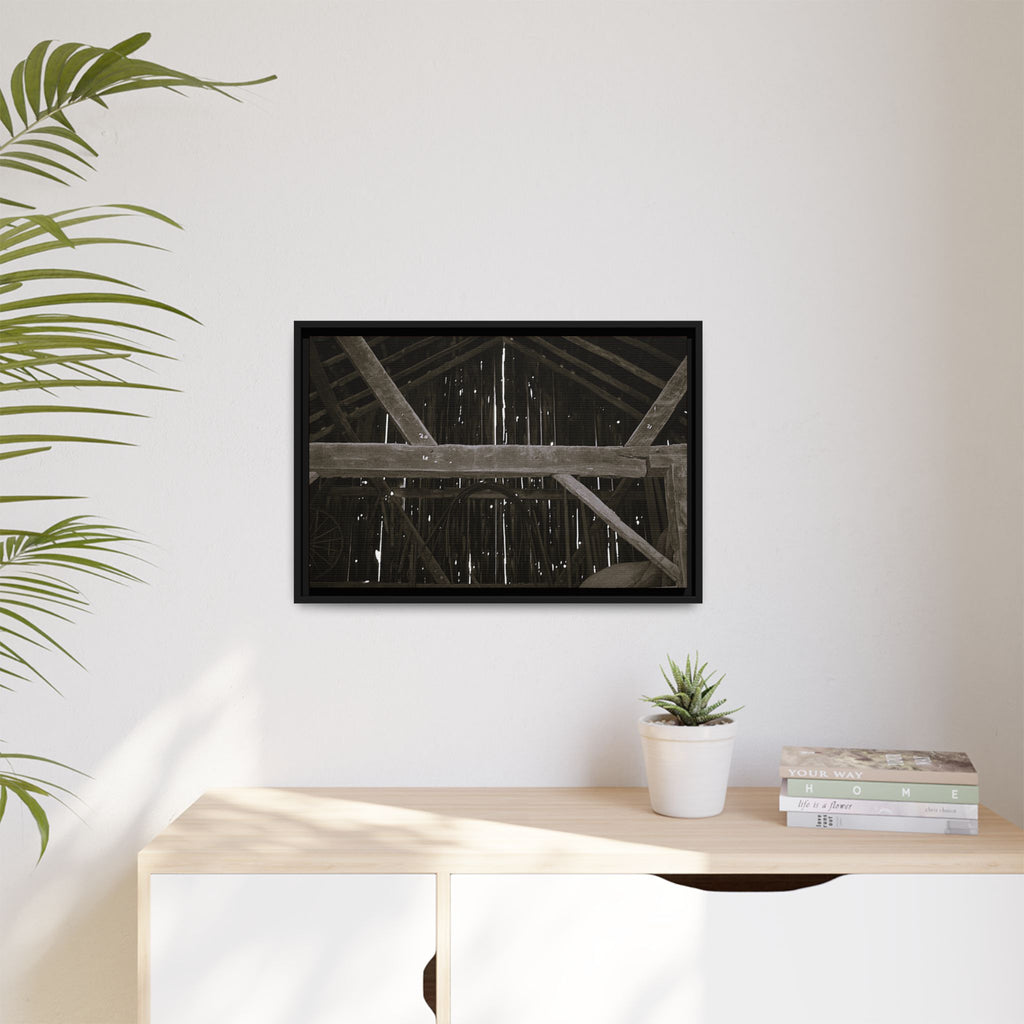 Rustic barn interior framed canvas print — moody looking-up view of weathered wooden beams and rafters with pinpoints of light, farmhouse photography wall art